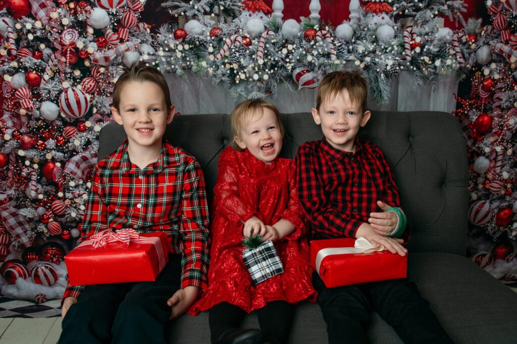 2 boys and 1 girl pose for in studio holiday family photo session with Just Peachy Photography in Palatine, IL 