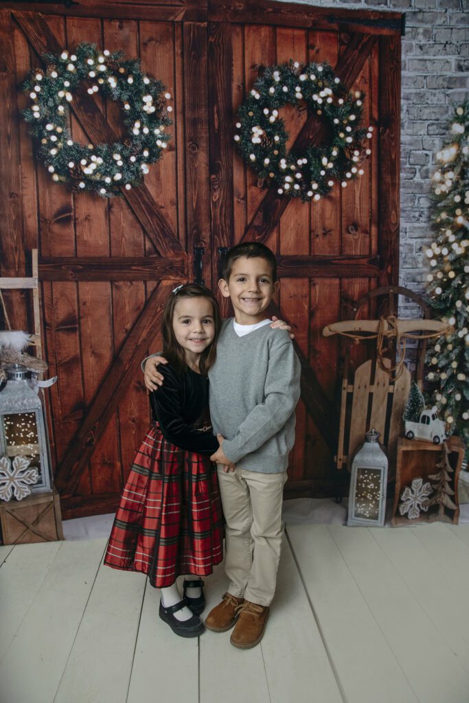 a boy and girl pose for in studio holiday family photo session with Just Peachy Photography in Palatine, IL 